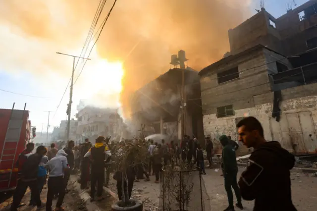 People stand by a burning building