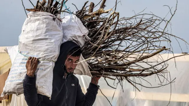 A man carries salvaged firewood