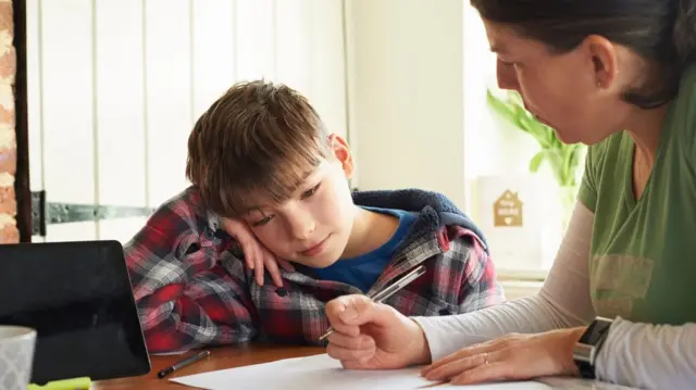 Boy doing homework with his mother