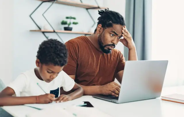 Stock image of dad and child working at home