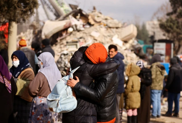 People embrace in the street, in the aftermath of a deadly earthquake, in Kahramanmaras, Turkey,