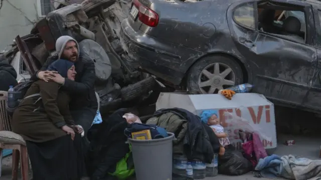 People wait for their loved ones trapped under rubble of collapsed buildings to be rescued