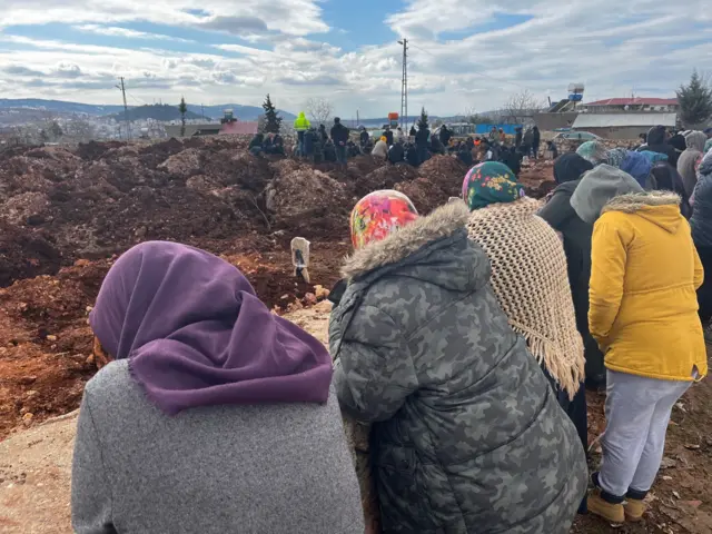 Residents gather at a mass burial site in Pazarcik