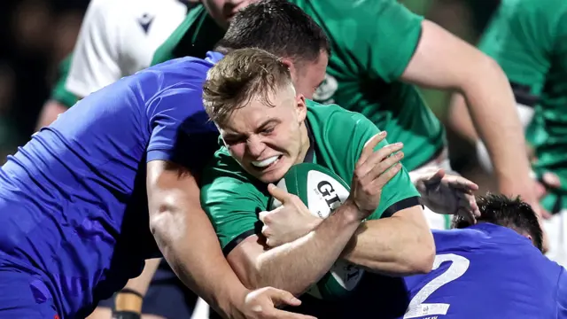 Ireland's Fintan Gunne is tackled by Zaccharie Affane and Barnabe Massa