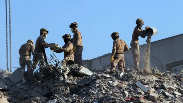 A rescue team search for survivors under a collapsed building in Hatay, southern Turkey