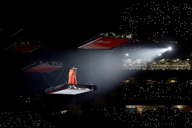 Rihanna performs on a platform above the pitch