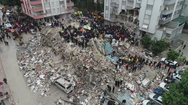 People search through rubble following an earthquake in Adana, Turkey