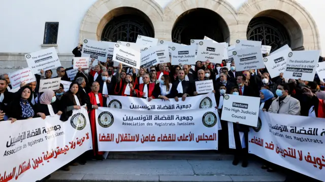 Tunisian judges display signs and banners during a protest against President Kais Saied's move to dissolve the Supreme Judicial Council, in Tunis, Tunisia, February 10, 2022.