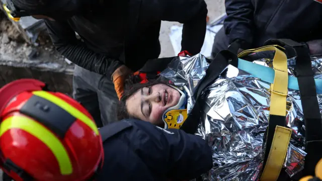 Rescuers carry Cudie, a 12-year-old Syrian girl who was trapped for 147 hours under the rubble of a collapsed building in Hatay, southern Turkey