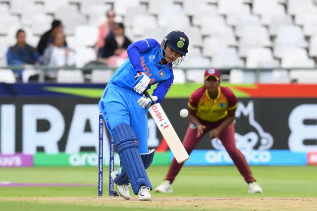 India's Smriti Mandhana (L) plays a shot during the Group B T20 women's World Cup cricket match between West Indies and India at Newlands Stadium in Cape Town