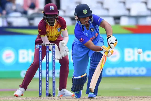 India's Richa Ghosh (R) plays a shot as West Indies' Rashada Williams (L) reacts during the Group B T20 women's World Cup cricket match between West Indies and India at Newlands Stadium in Cape Town