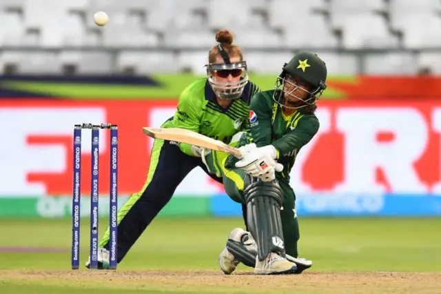 Pakistan's Muneeba Ali (R) plays a shot as Ireland's wicketkeeper Mary Waldron (L) looks on during the Group B T20 women's World Cup cricket match between Pakistan and Ireland at Newlands Stadium in Cape Town