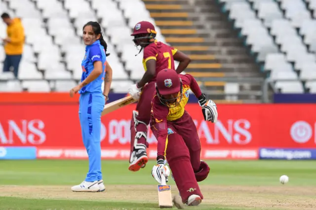 West Indies' Shemaine Campbelle (R) runs between the wickets as India's Renuka Singh Thakur (L) looks on during the Group B T20 women's World Cup cricket match between West Indies and India at Newlands Stadium in Cape Town