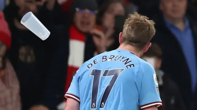 A plastic cup is thrown towards Manchester City midfielder Kevin de Bruyne