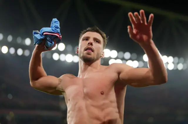 Ruben Dias takes off his shirt to throw to the crowd after Manchester City's win at Arsenal