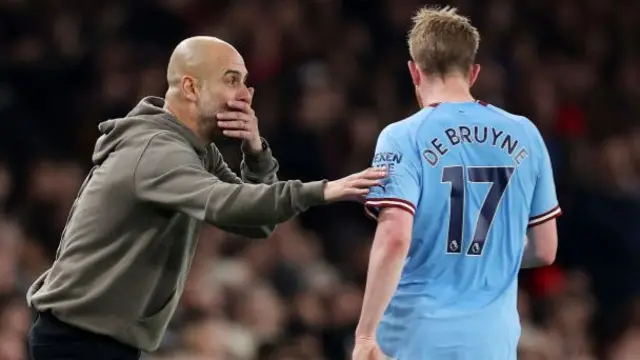 Pep Guardiola speaks with Kevin de Bruyne