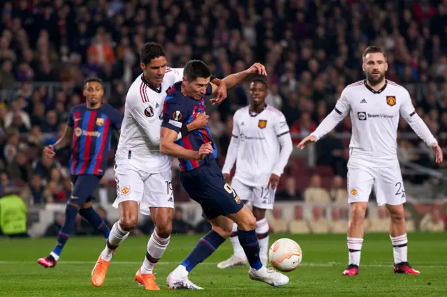 Raphael Varane tackles Robert Lewandowski.