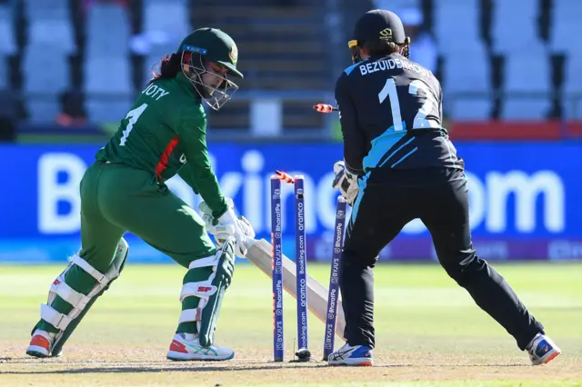 Bangladesh's Nigar Sultana Joty (L) looks on after being bowled by New Zealand's Amelia Kerr (not seen) as New Zealand's wicketkeeper Bernardine Bezuidenhout (R) reacts during the Group A T20 women's World Cup cricket match between New Zealand and Bangladesh at Newlands Stadium