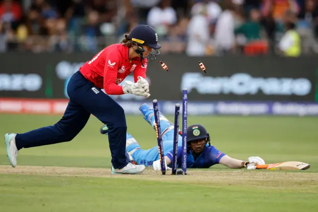 England's wicketkeeper Amy Jones (L) runs out India's Deepti Sharma (R) during the Group B T20 women's World Cup cricket match between England and India at St George's Park in Gqeberha