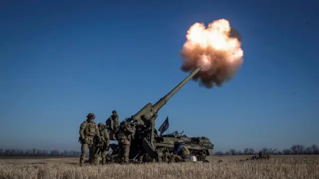 Ukrainian troops fire a self-propelled gun