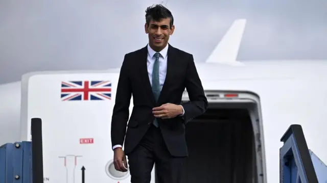 Rishi Sunak steps off a plane in Munich