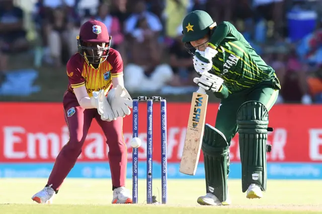 Pakistan's Fatima Sana (R) plays a shot as West Indies' wicketkeeper Rashada Williams (R) looks on during the Group B T20 women's World Cup cricket match between Pakistan and West Indies at Boland Park in Paarl