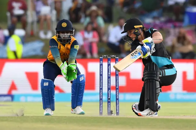 New Zealand's Bernardine Bezuidenhout (R) plays a shot as Sri Lanka's wicketkeeper Anushka Sanjeewani (L) looks on during the Group A T20 women's World Cup cricket match between New Zealand and Sri Lanka at Boland Park in Paarl