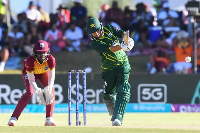 Pakistan's Nida Dar (R) watches the ball after playing a shot as West Indies' wicketkeeper Rashada Williams (R) looks on during the Group B T20 women's World Cup cricket match between Pakistan and West Indies at Boland Park in Paarl