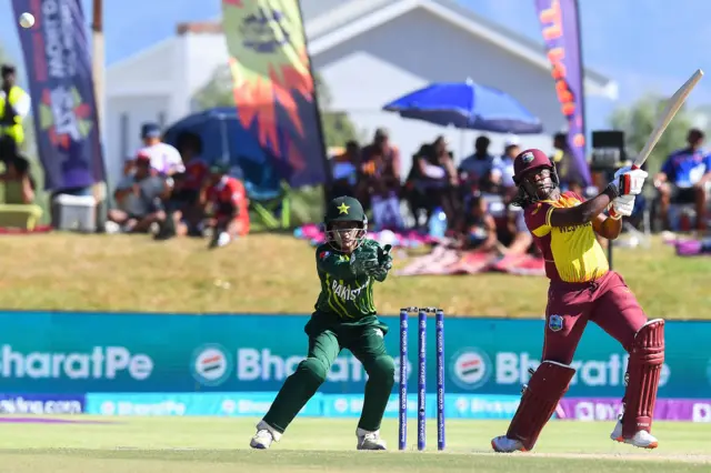 West Indies' Aaliyah Alleyne (R) watches the ball after playing a shot as Pakistan's wicketkeeper Muneeba Ali (L) reacts during the Group B T20 women's World Cup cricket match between Pakistan and West Indies at Boland Park