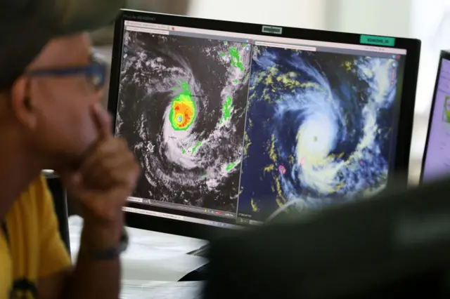 Forecasters watch satellite control screens as they monitor Cyclone Freddy