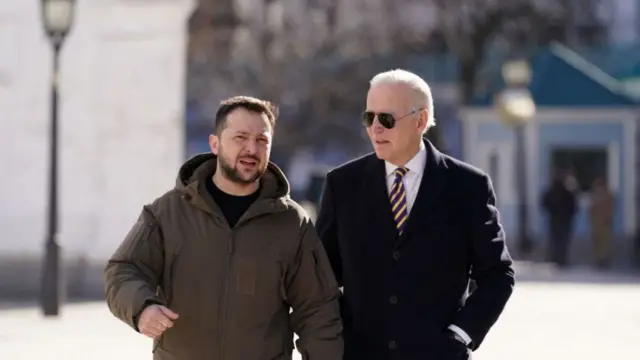 US President Joe Biden (R) walks next to Ukrainian President Volodymyr Zelensky (L)