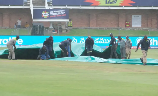 Ground staff protect the crease as rains stops the Group B T20 women's World Cup cricket match between India and Ireland at St George's Park in Gqeberha