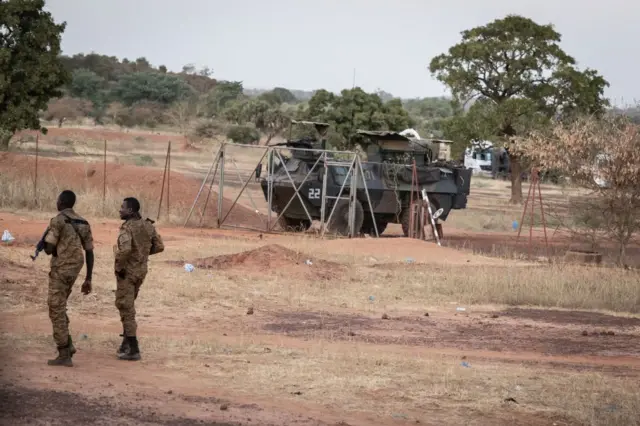 Burkina Faso army officers patrol near a French armoured vehicle parked in Kaya, capital of Burkina Faso's