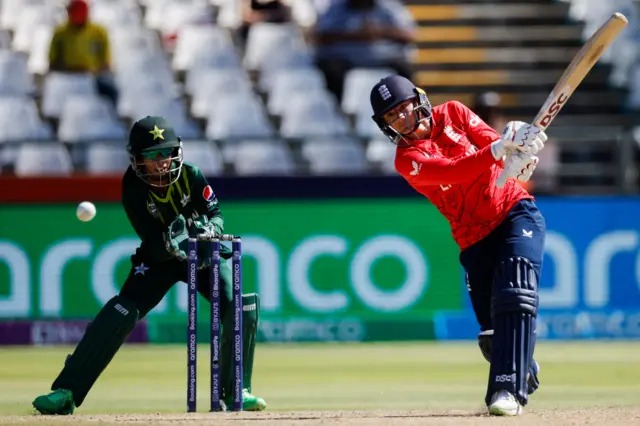 England's Danni Wyatt plays a shot (R) while Pakistan's Muneeba Ali (L) looks on during the Group B T20 women's World Cup cricket match between England and Pakistan at Newlands Stadium in Cape Town