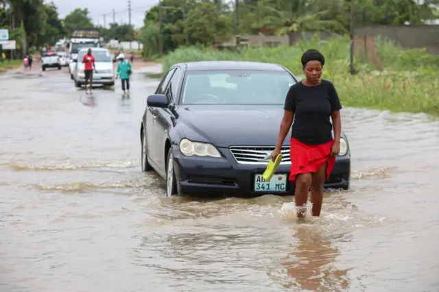 A woman walks through one of the flooded streets