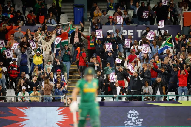 South Africa's supporters celebrate after South Africa's Tazmin Brits hits a four during the Group A T20 women's World Cup cricket match between South Africa and Bangladesh at Newlands Stadium in Cape Town