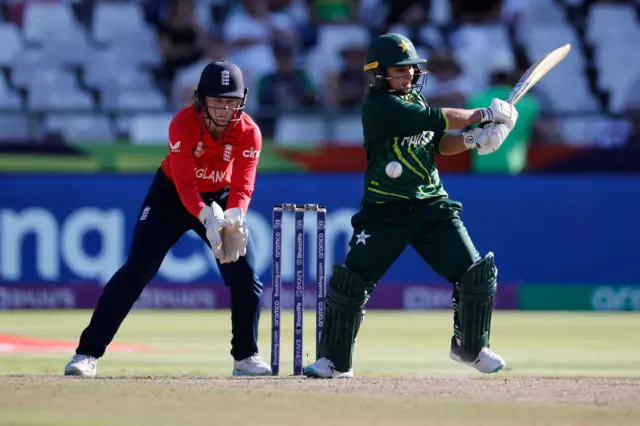 Pakistan's Nida Dar (R) plays a shot as England's wicketkeeper Amy Jones (L) reacts during the Group B T20 women's World Cup cricket match between England and Pakistan at Newlands Stadium in Cape Town