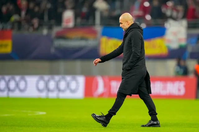 Man City boss Pep Guardiola walks across the pitch at the Red Bull Arena