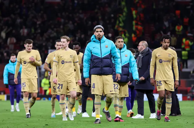 A dejected Barcelona team walk off the pitch.