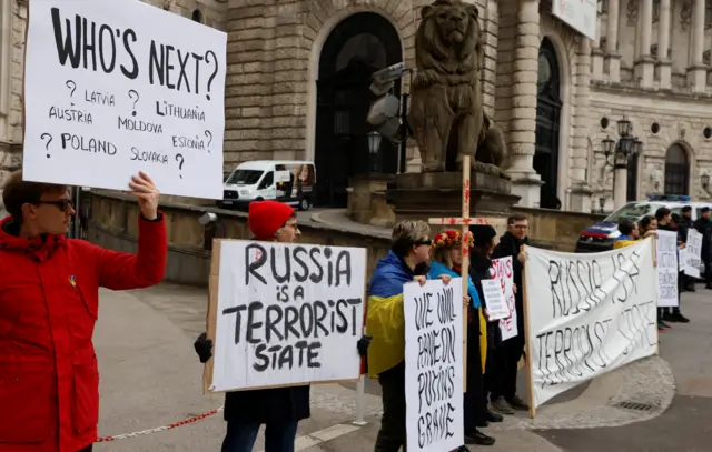 Protesters stand outside Vienna's Hofburg Palace ahead of the OSCE parliamentary assembly