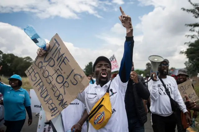 Members of #StandUpSA and #NotInMyName movement chant slogans during their march to Eskom Megawatt Park, the headquarters of Eskom power utility company, in Johannesburg on February 2, 2023.