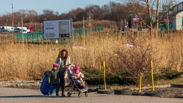 A woman with her two children and suitcases in Ukraine