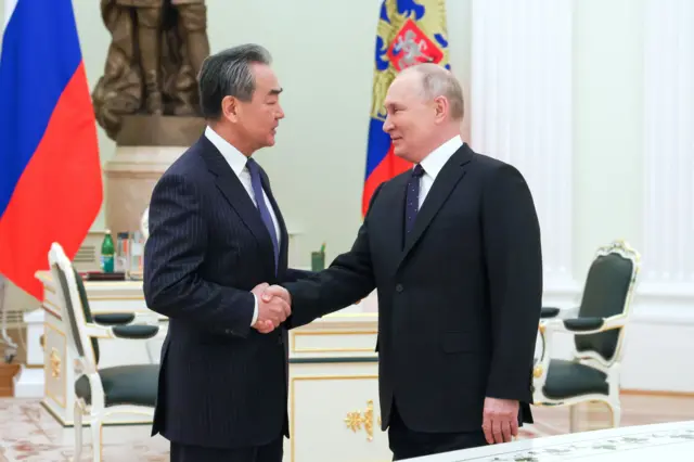 Russian President Putin shaking hands with China's top diplomat Wang Yi in Moscow