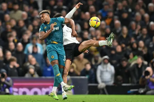 Wolves' Adama Traore competes with Fulham defender Antonee Robinson