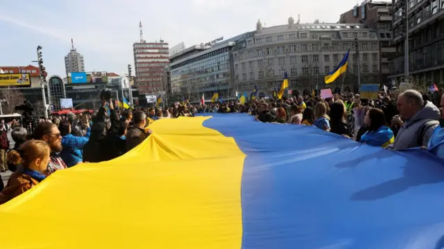 People take part in a rally to mark the one-year anniversary of Russia's invasion of Ukraine, in Belgrade