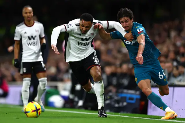 Kenny Tete of Fulham battles for possession with Hugo Bueno of Wolves