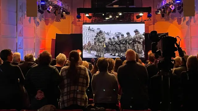 The audience standing and singing