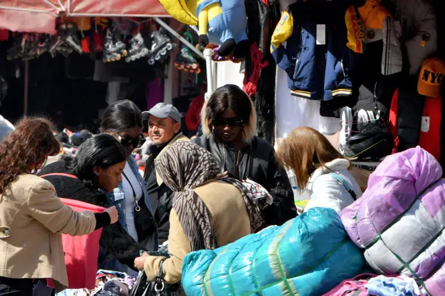 Sub-Saharan African women look for clothes in a thrift store in the market of Ariana, on the northern outskirts of Tunis on February 22, 2023.