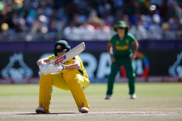 Australia's Beth Mooney (L) ducks under a ball delivered by South Africa's Shabnim Ismail (not seen) during the final T20 women's World Cup cricket match between South Africa and Australia at Newlands Stadium in Cape Town