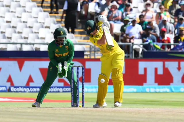 Australia's Alyssa Healy (R) plays a shot as South Africa's wicketkeeper Sinalo Jafta (L) looks on during the final T20 women's World Cup cricket match between South Africa and Australia at Newlands Stadium in Cape Town